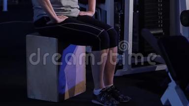 以坐姿伸展膝盖处的腿。 一位年长的女子练习关节体操。 复制空间。 侧视